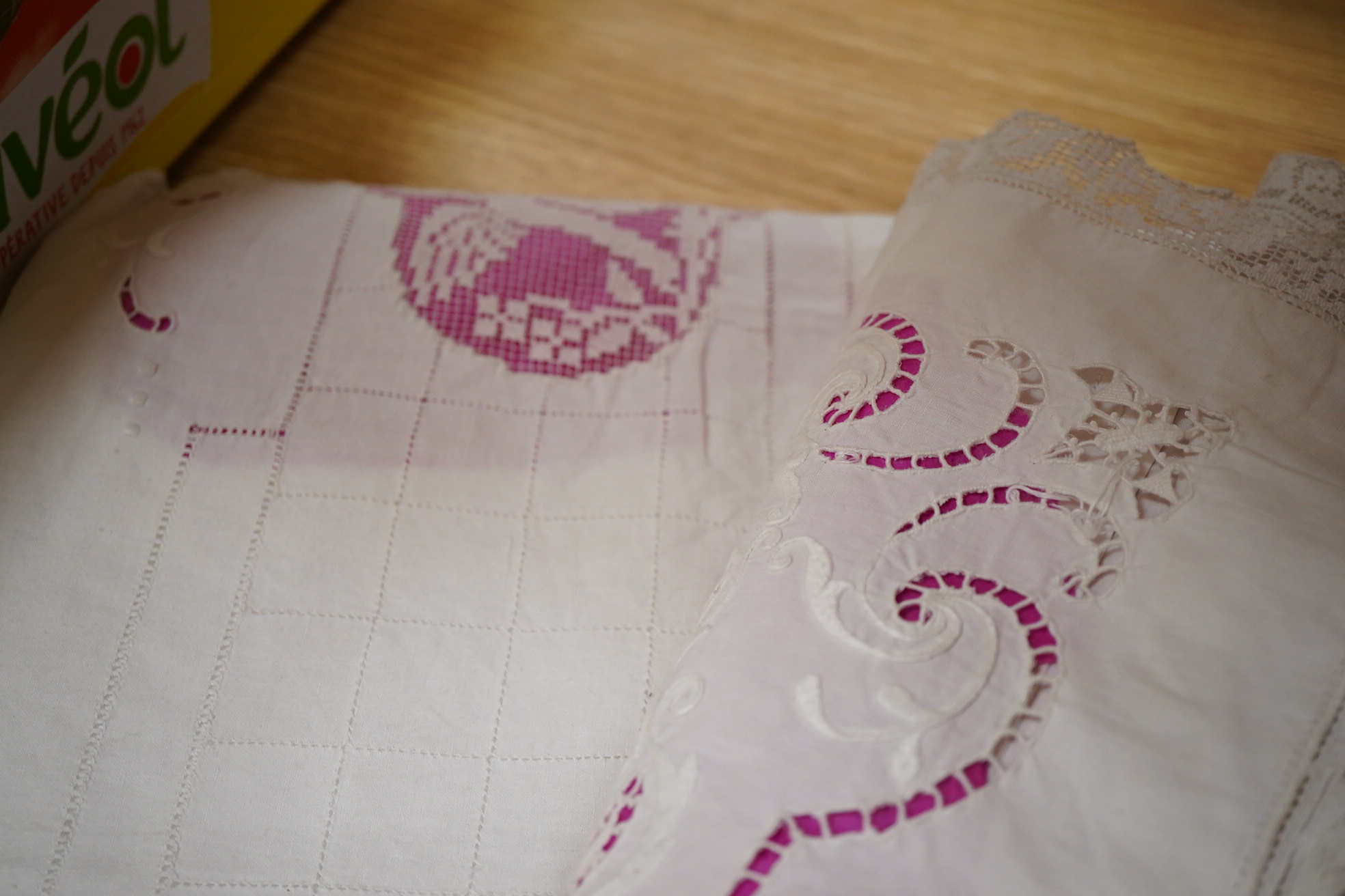 A late 19th / early 20th century continental fine linen top sheet and near matching square pillowcase. The sheet designed with an ornate turn back with a fillet putti inset, fillet bird insets, a cut work embroidery cart